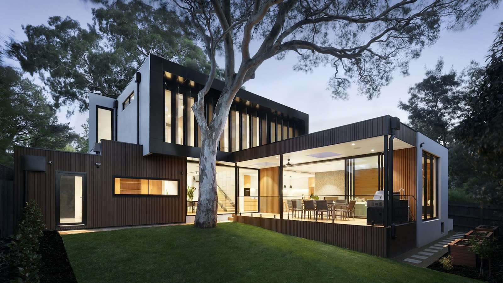 Casa moderna com fachada iluminada ao anoitecer