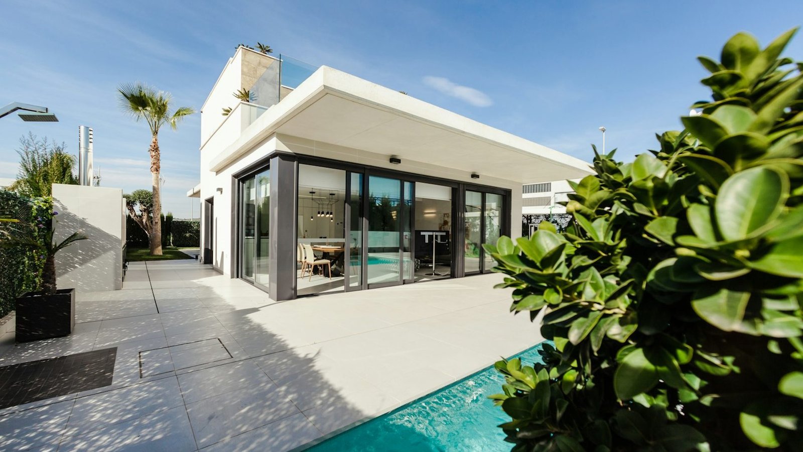 Casa contemporânea com grandes vãos de vidro e paisagismo