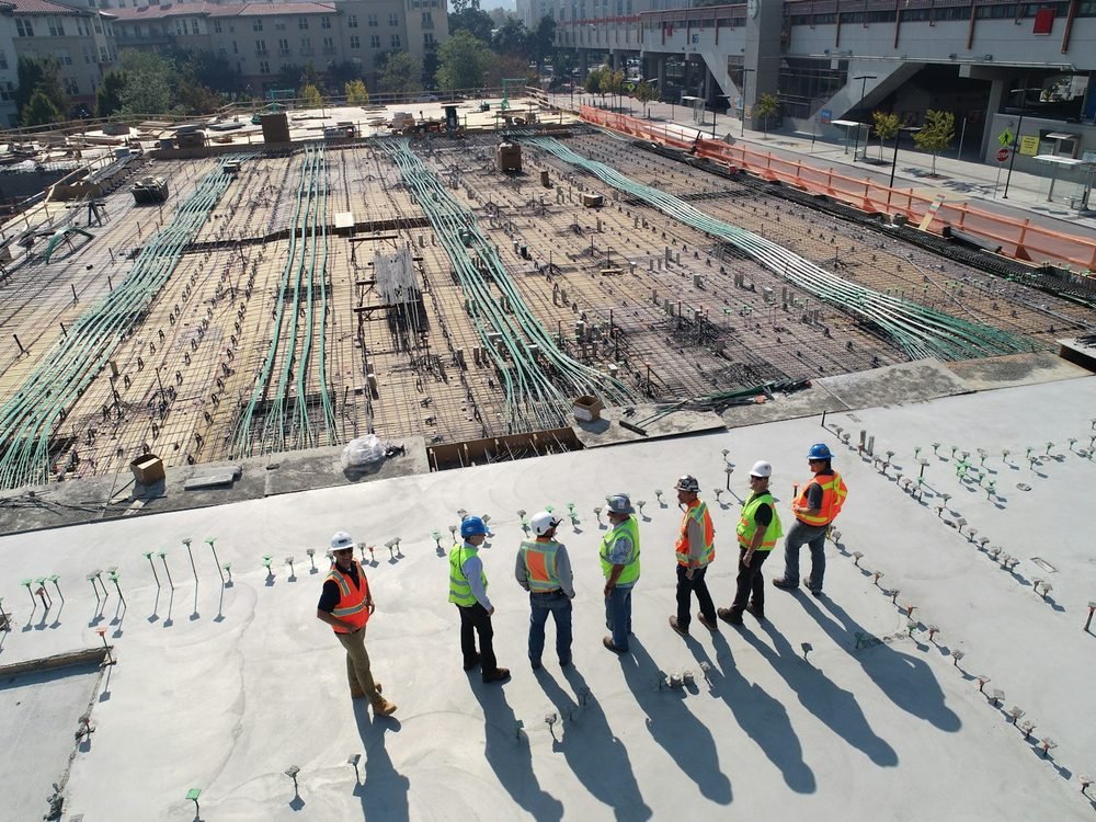 Equipe de obra sobre a laje de fundação de uma construção residencial